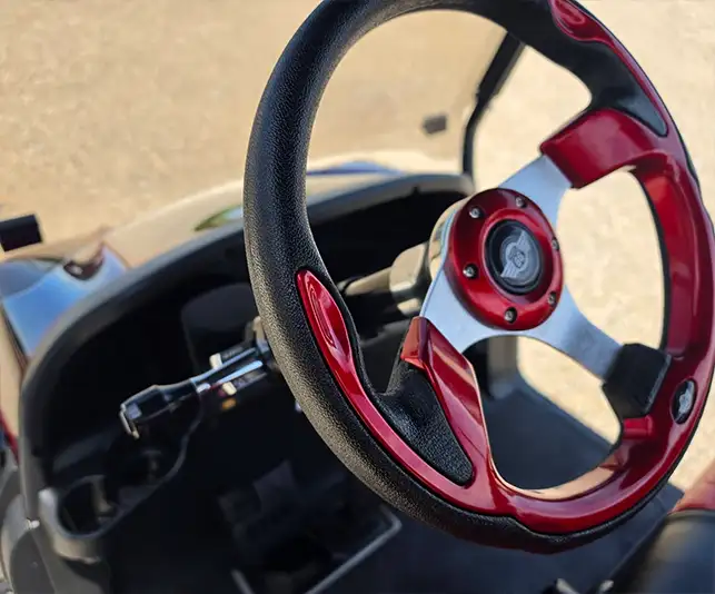 Close-up of a custom red and chrome steering wheel on a golf cart customized by CSC Motor Company near Edwardsville, IL