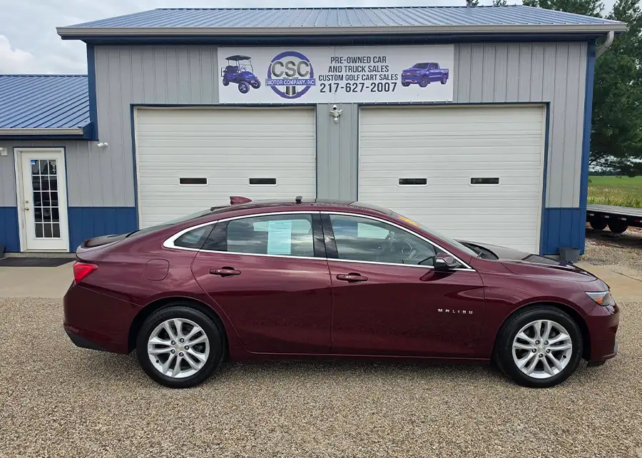 Used maroon Chevy Malibu parked outside the CSC Motor Company dealership near Jacksonville, IL