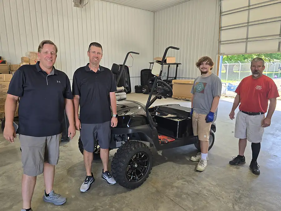 CSC Motor Company staff working on a custom built black golf cart in the Springfield, IL repair shop