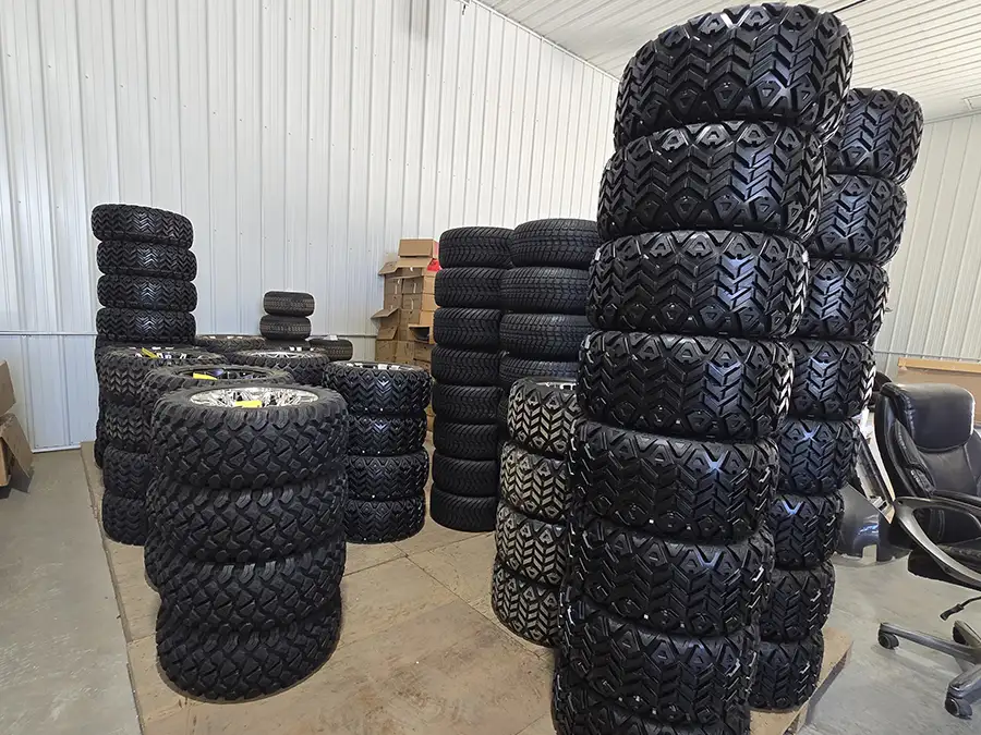 Stacks of all-terrain golf cart tires and wheels in CSC Motor Company's Springfield, IL shop