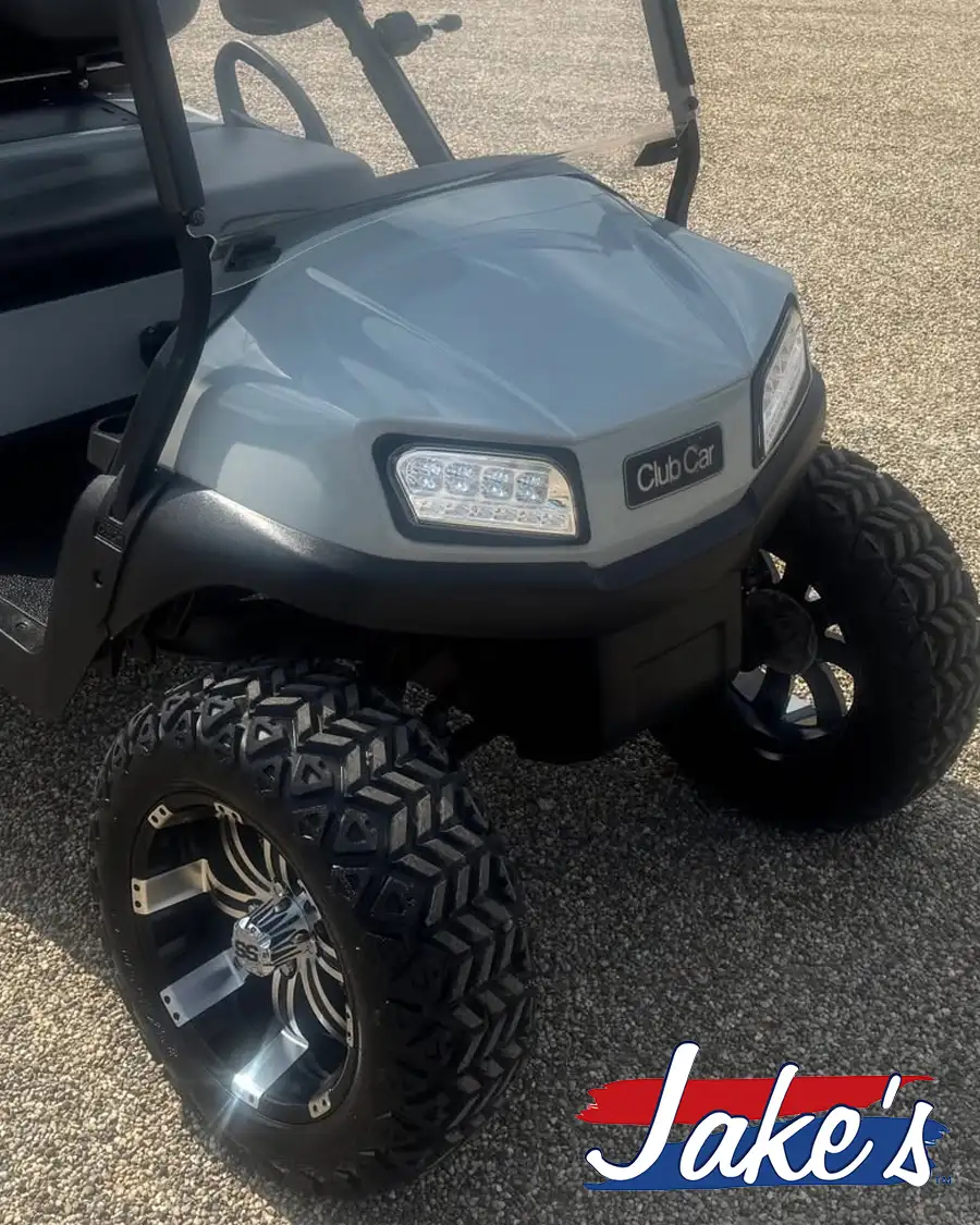 Close-up of gray Club Car golf cart front end with LED headlights and Jake's lift kit wheels – CSC Motor Company Springfield, IL