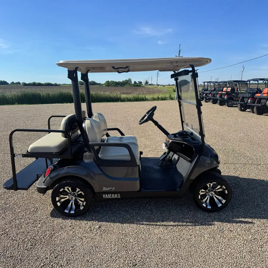 Gray Yamaha golf cart with tan seats and chrome wheels parked on gravel lot – CSC Motor Company Springfield, IL