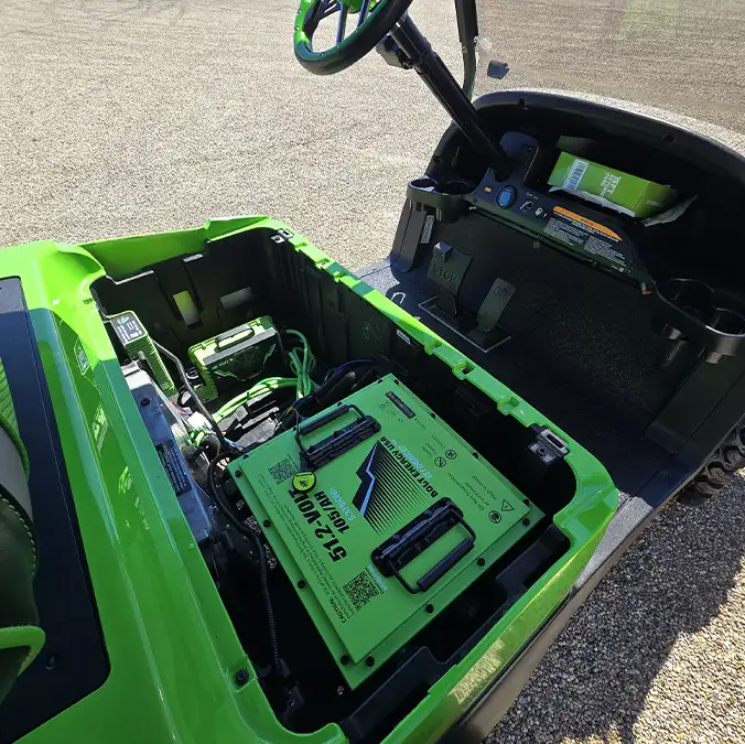 Overhead view of green Bolt Energy lithium battery installed in lime green golf cart – CSC Motor Company Springfield, IL