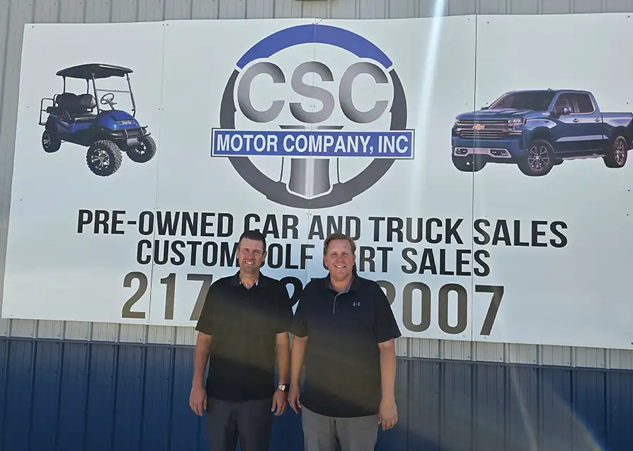CSC Motor Company owners standing in front of business sign near Springfield, IL